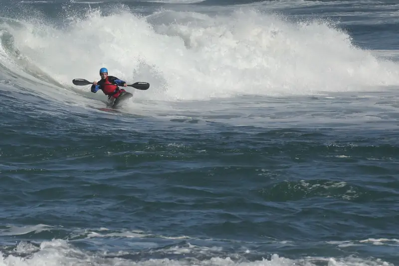 Adventurer tackles ocean waves in a kayak, showcasing thrilling outdoor water sports