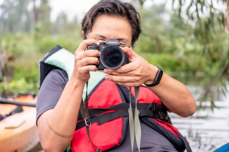 A man wearing a life jacket takes photos from his kayak in CDMX, Mexico